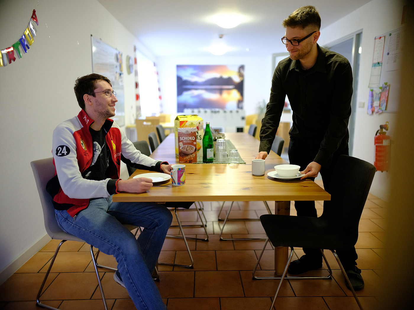 Zwei junge Männer am Tisch in ihrer Wohngruppe