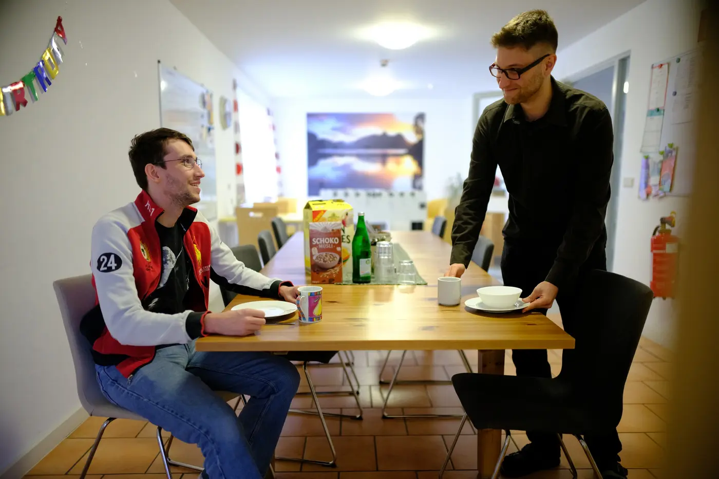 Zwei junge Männer am Tisch in ihrer Wohngruppe